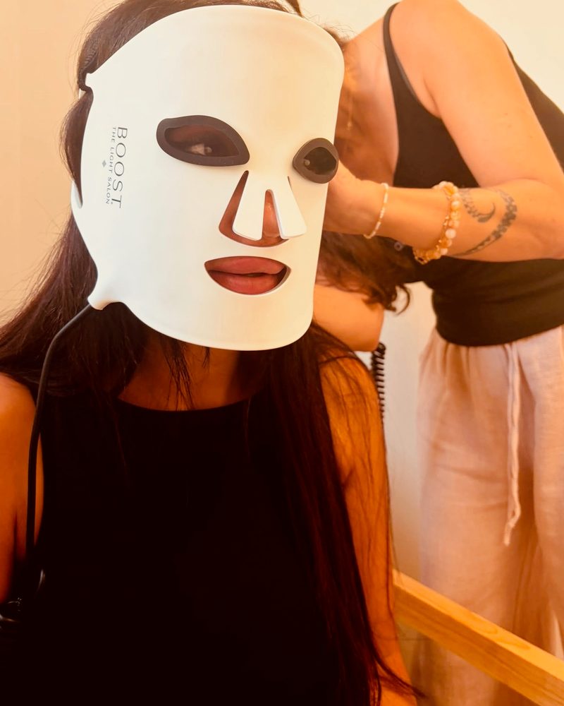 Béatrice Bazile ajuste le masque LED Boost Light d'une cliente
