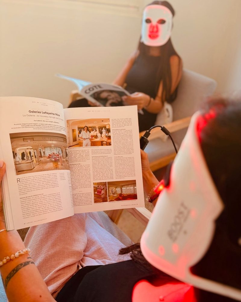 Séance de masque LED Boost Light en lumière rouge, moment de détente avec un magazine